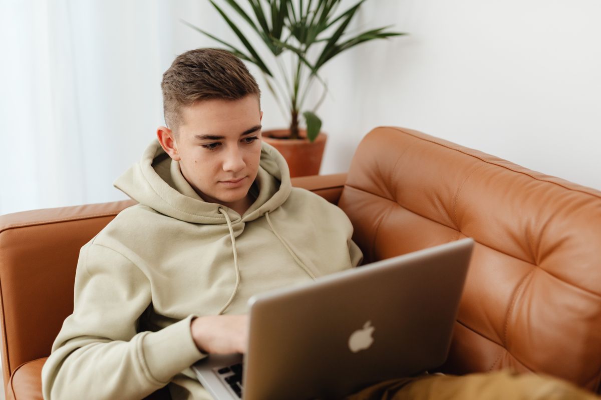 A teenager working through the course on a laptop at home.
